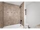 Bathroom featuring tile shower with bronze fixtures and a white tub at 200 S Bayshore Blvd, Clearwater, FL 33759
