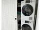 The laundry room features a stackable white washer and dryer and shelving for storing linens at 2256 Spanish Dr # 42, Clearwater, FL 33763