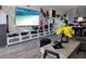 This living room has hardwood floors, white shelves, decor, modern art and a large flat screen television at 2256 Spanish Dr # 42, Clearwater, FL 33763