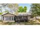 Rear exterior of the home featuring a screened in patio with outdoor dining at 2427 Comerwood Dr, Spring Hill, FL 34609
