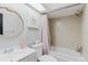 A bathroom with a shower-tub combo, single sink vanity, and a decorative round mirror at 2427 Comerwood Dr, Spring Hill, FL 34609