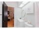 A light filled bathroom featuring a single sink vanity and artwork, with a view into the next room at 2427 Comerwood Dr, Spring Hill, FL 34609