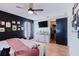 Primary bedroom with black accent wall, a ceiling fan, and a walk in closet at 2427 Comerwood Dr, Spring Hill, FL 34609