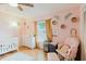 A cozy, charming Bedroom featuring a crib, changing table, and soothing pink walls at 2427 Comerwood Dr, Spring Hill, FL 34609