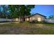 Exterior facade of the home with warm exterior lighting and mature landscaping at 2427 Comerwood Dr, Spring Hill, FL 34609