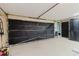 Garage with large closed black garage door and speckled flooring throughout the interior at 2427 Comerwood Dr, Spring Hill, FL 34609