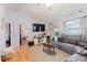 Comfortable living room featuring hardwood floors, a cozy couch, and a large flat screen TV at 2427 Comerwood Dr, Spring Hill, FL 34609