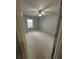 An empty bedroom with neutral carpet, light gray walls, a ceiling fan, and a window, viewed through an open door at 2900 W Azeele St # H, Tampa, FL 33609