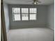 A serene bedroom space with neutral carpeting and ample natural light from multiple windows at 2900 W Azeele St # H, Tampa, FL 33609