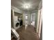 Hallway showing laundry area with modern washer/dryer, bedroom entrance, and hardwood flooring leading to stairs at 2900 W Azeele St # H, Tampa, FL 33609