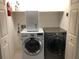 Bright laundry room features modern washer and dryer with a shelf above for storage solutions at 2900 W Azeele St # H, Tampa, FL 33609