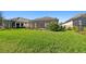 Spacious backyard with lush green grass, featuring a screened-in lanai perfect for outdoor enjoyment at 4228 Isonzo Way, Wesley Chapel, FL 33543