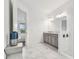 Bright bathroom featuring double vanity, marble tile flooring, and a glimpse into the Primary bedroom at 4228 Isonzo Way, Wesley Chapel, FL 33543