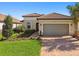 Charming single-story home with a paver driveway, tile roof, and beautifully landscaped front yard at 4228 Isonzo Way, Wesley Chapel, FL 33543