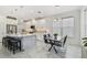 Bright kitchen features a modern dining table, center island, marble floors, stainless steel appliances, and pendant lighting at 4228 Isonzo Way, Wesley Chapel, FL 33543