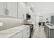 Modern kitchen featuring stainless steel appliances, gray backsplash, quartz counters and an adjacent breakfast area at 4228 Isonzo Way, Wesley Chapel, FL 33543