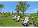Inviting lawn featuring green grass and Adirondack chairs, perfect for relaxation at 4228 Isonzo Way, Wesley Chapel, FL 33543
