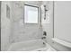 Bright bathroom featuring marble-style tile surround, modern fixtures, and built-in shelves at 4501 24Th S Ave, St Petersburg, FL 33711