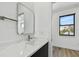 Bathroom featuring sleek vanity with modern fixtures and a large mirror, complemented by natural light from the window at 4501 24Th S Ave, St Petersburg, FL 33711