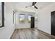 Light-filled bedroom with wood floors, a ceiling fan, and three windows overlooking a tree-lined street at 4501 24Th S Ave, St Petersburg, FL 33711