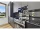 A modern kitchen features sleek black cabinets, stainless steel appliances, and granite countertops at 4501 24Th S Ave, St Petersburg, FL 33711