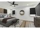 This main bedroom features a ceiling fan, decorative mirror, wood floors, and an upholstered bed frame at 4501 24Th S Ave, St Petersburg, FL 33711