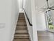 Modern staircase with hardwood steps, black railing, and natural light at 4501 24Th S Ave, St Petersburg, FL 33711