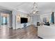 Open concept living room with hardwood floors, large TV, and comfortable white sofa at 4968 Reflecting Pond Cir, Wimauma, FL 33598