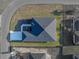 An aerial view of a home with a dark roof, green yard and concrete driveway, situated on a well-maintained street at 5433 Chestnut Ridge Rd, Dade City, FL 33523