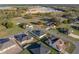 Aerial view of a home in a residential neighborhood, surrounded by green spaces and near a body of water on a clear day at 5433 Chestnut Ridge Rd, Dade City, FL 33523
