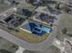 Aerial view of a single-Gathering home with a dark roof and a light-colored driveway, in a suburban neighborhood on a sunny day at 5433 Chestnut Ridge Rd, Dade City, FL 33523