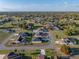 Aerial view of a single Gathering home in a neighborhood surrounded by green spaces and trees under a blue sky at 5433 Chestnut Ridge Rd, Dade City, FL 33523