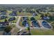 Aerial view of a house in a residential area surrounded by trees and lawns, with a winding street and various homes nearby at 5433 Chestnut Ridge Rd, Dade City, FL 33523