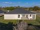 Aerial view of a backyard with a covered patio, lush lawn, and mature trees at 5433 Chestnut Ridge Rd, Dade City, FL 33523