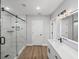 Bathroom featuring a glass shower with pebble floor and illuminated mirror at 5433 Chestnut Ridge Rd, Dade City, FL 33523