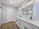 Bathroom featuring double sinks with black hardware and an illuminated mirror at 5433 Chestnut Ridge Rd, Dade City, FL 33523
