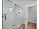 Modern bathroom featuring a glass shower with pebble floor and marble-style tile surround at 5433 Chestnut Ridge Rd, Dade City, FL 33523