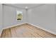 Neutral bedroom featuring light wood flooring, white walls, and a window with natural light at 5433 Chestnut Ridge Rd, Dade City, FL 33523