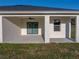 Relaxing covered patio with ceiling fan and double door access to the home's interior at 5433 Chestnut Ridge Rd, Dade City, FL 33523