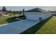 Long concrete driveway leading to a two-car garage, surrounded by well-maintained landscaping at 5433 Chestnut Ridge Rd, Dade City, FL 33523