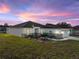 Exterior of a well-maintained home featuring a manicured lawn and clean architectural lines at dusk at 5433 Chestnut Ridge Rd, Dade City, FL 33523