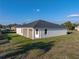 Rear exterior of house showing stucco siding, covered patio and surrounding green lawn at 5433 Chestnut Ridge Rd, Dade City, FL 33523