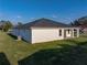 An exterior view of the home highlighting its simple, modern design and surrounding green lawn at 5433 Chestnut Ridge Rd, Dade City, FL 33523