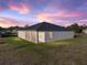 A beautiful exterior view of the home at sunset, featuring a well-manicured lawn at 5433 Chestnut Ridge Rd, Dade City, FL 33523