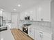Modern kitchen with stainless steel appliances, white cabinetry, stone countertops, and tile backsplash at 5433 Chestnut Ridge Rd, Dade City, FL 33523