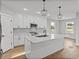 Bright kitchen featuring white cabinets, stainless steel appliances, a large island, and stylish pendant lighting at 5433 Chestnut Ridge Rd, Dade City, FL 33523