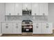 Modern kitchen with stainless steel appliances, white cabinetry, stone countertops, and tile backsplash at 5433 Chestnut Ridge Rd, Dade City, FL 33523