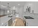 Bright kitchen featuring white cabinets, stainless steel appliances, a large island, and stylish pendant lighting at 5433 Chestnut Ridge Rd, Dade City, FL 33523