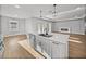 Open kitchen with modern island, stainless steel appliances, and fireplace in the background at 5433 Chestnut Ridge Rd, Dade City, FL 33523