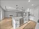 Bright kitchen featuring white cabinets, stainless steel appliances, a large island, and stylish pendant lighting at 5433 Chestnut Ridge Rd, Dade City, FL 33523